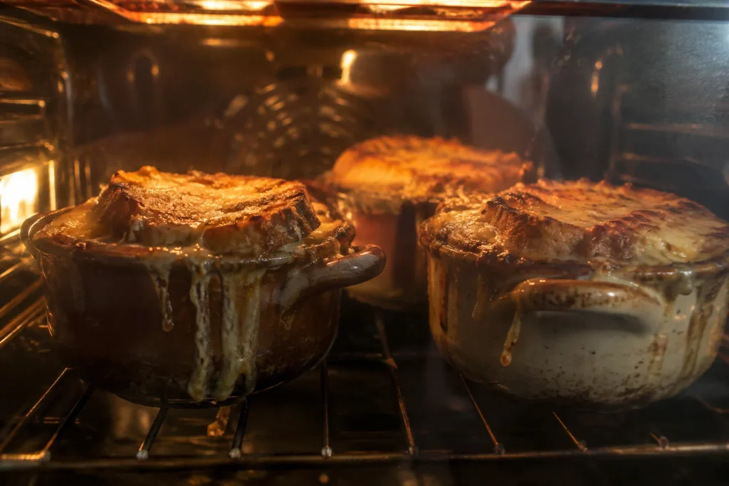 French Onion Soup Recipe: A Golden, Deeply Caramelized French Classic in 6 Steps 6 Crocks of French onion soup bubbling under a hot broiler