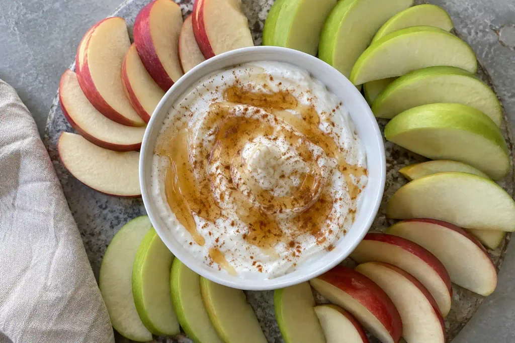 Healthy Snacks: 12 Simple Recipes to Grab Fast or Make Ahead 2 Bowl of Greek yogurt dip with honey and cinnamon beside fanned apple slices on a stone board