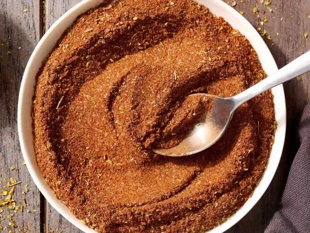 Taco Seasoning Recipe: A Smoky Homemade Spice Blend Ready in 5 Minutes 2 Homemade taco seasoning blend in a white bowl with a spoon on a wooden surface.