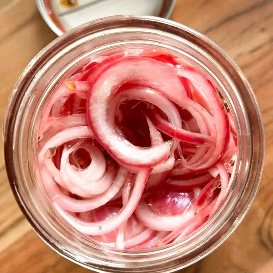 Overhead view of homemade pickled red onions in a glass jar