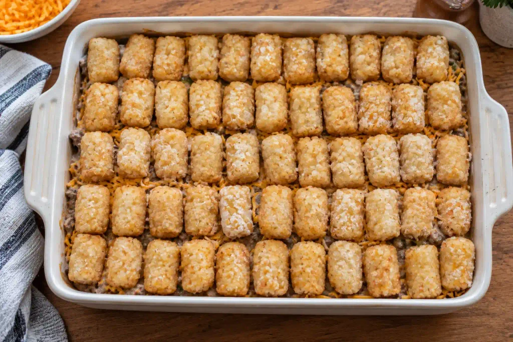 Tater Tot Casserole Recipe: Crispy Tots Over a Beef Filling, Serves 8 5 Frozen tots packed in tight rows over filling in a cheesy tot casserole dish